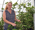 Anna Timmerman next to a green bush.
