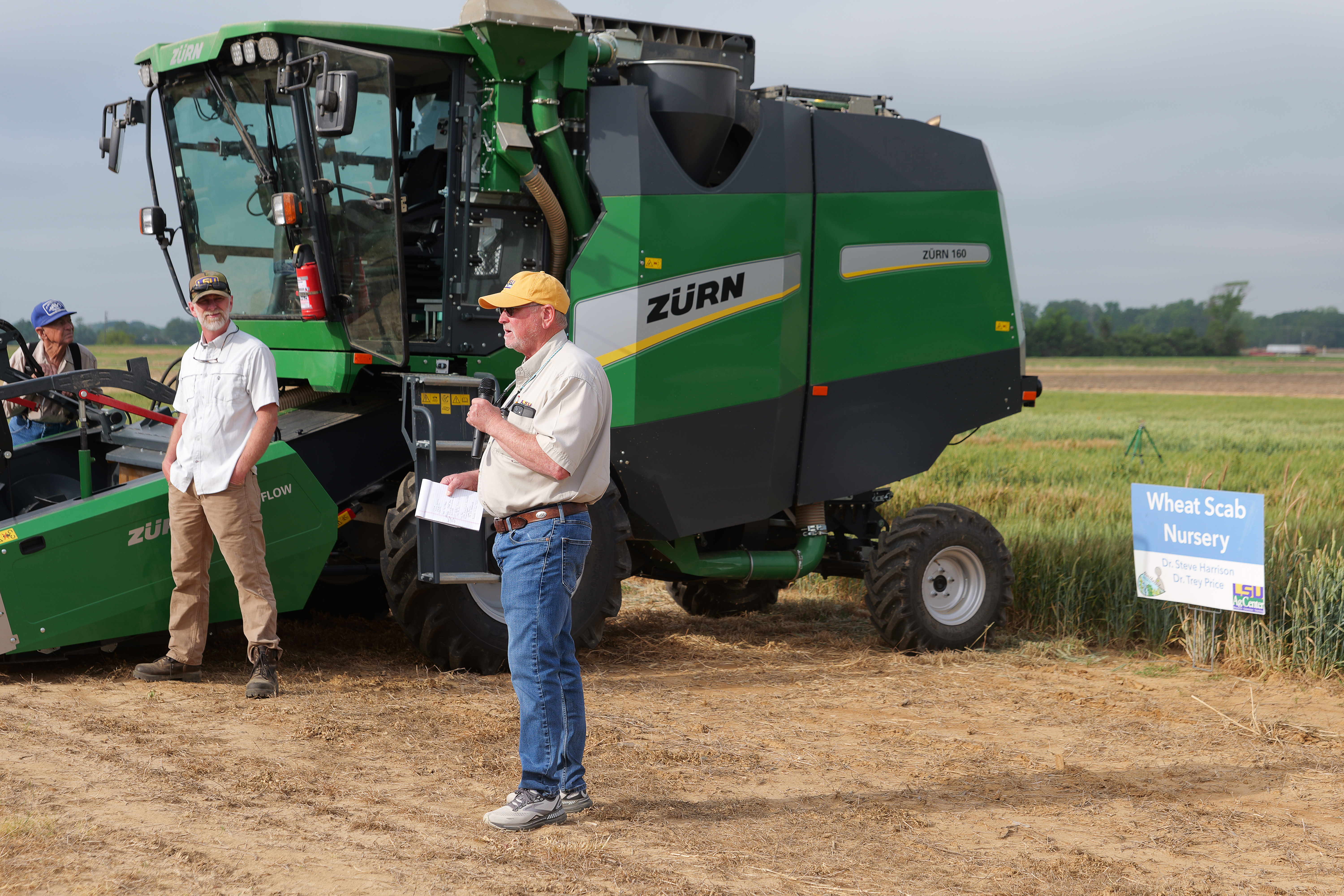 Two men standing near tractor.