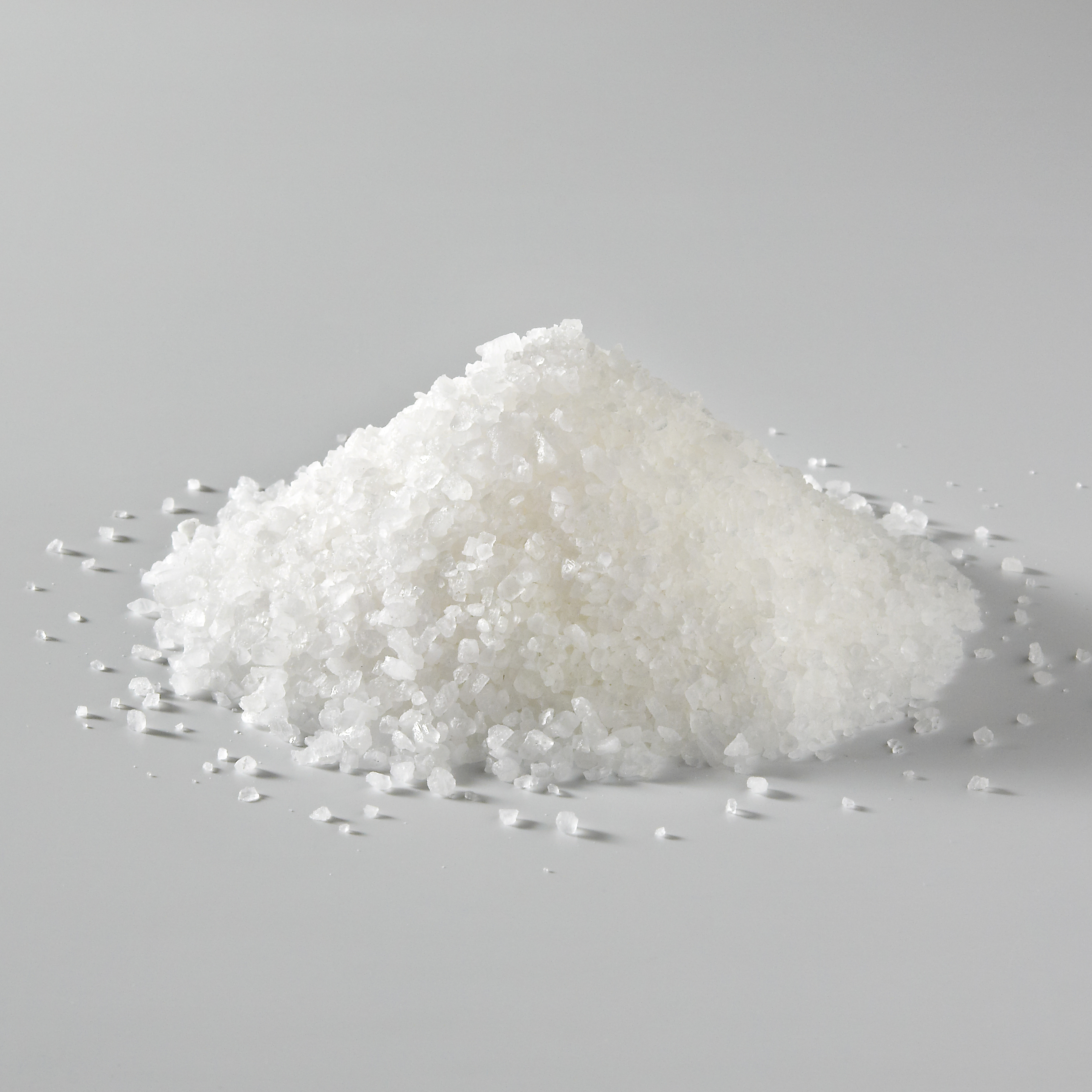 A pile of salt lies on a table.