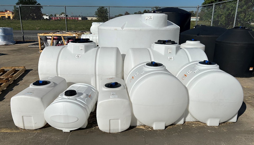 A row of white tanks sits on the ground.