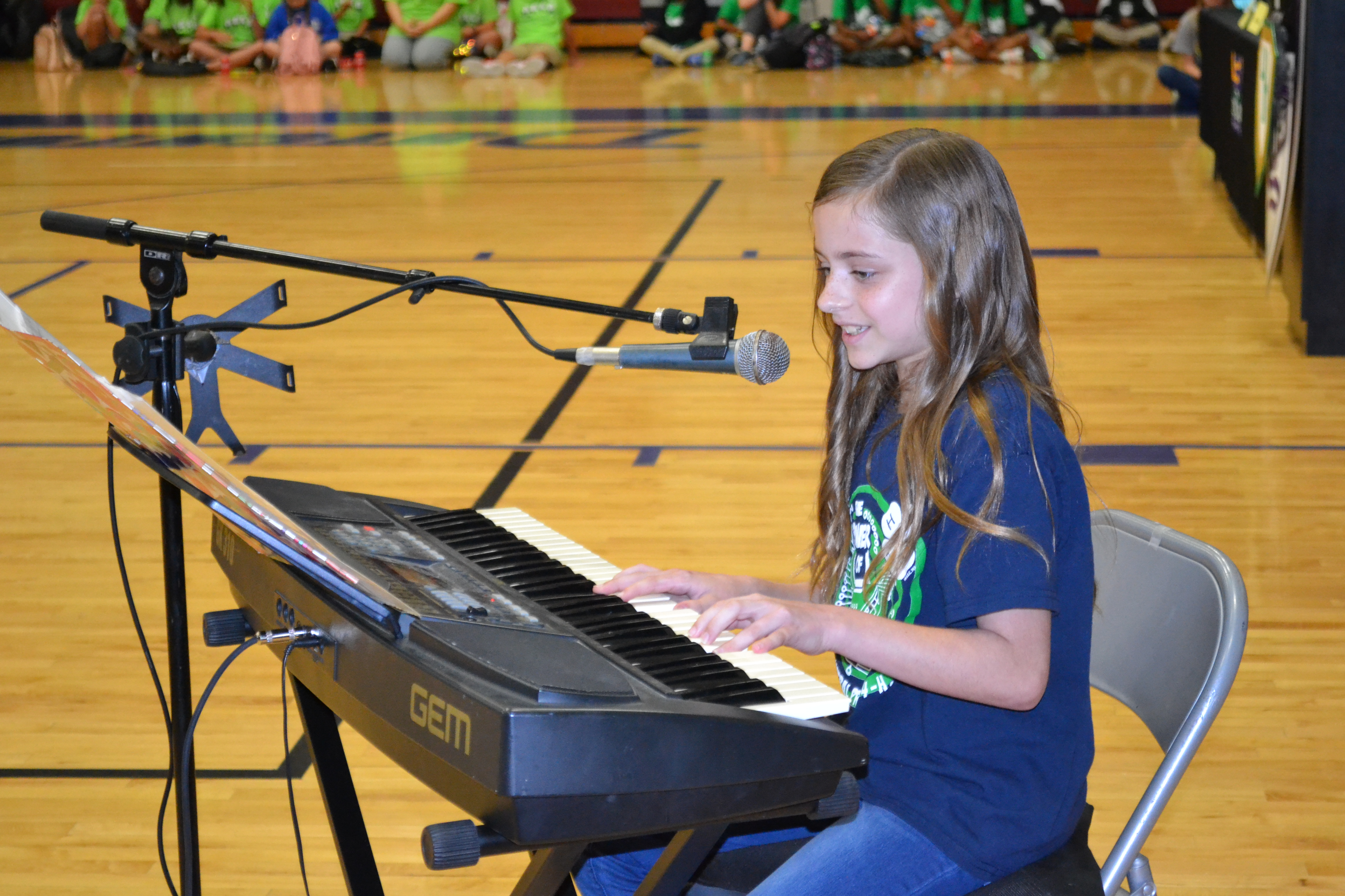 Youth sitting at a keyboard.