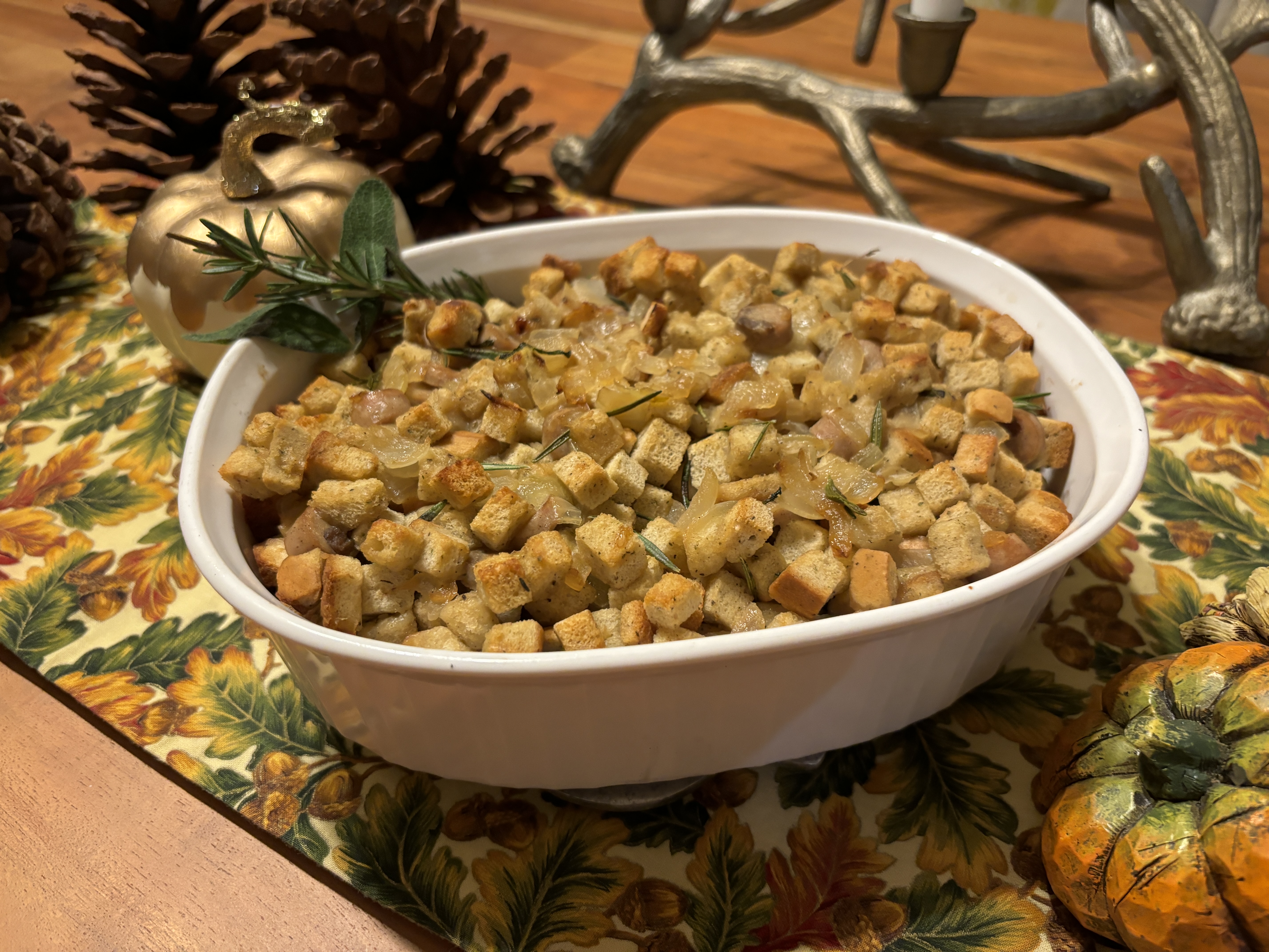 Stuffing in a white baking dish on table with fall-themed decorations