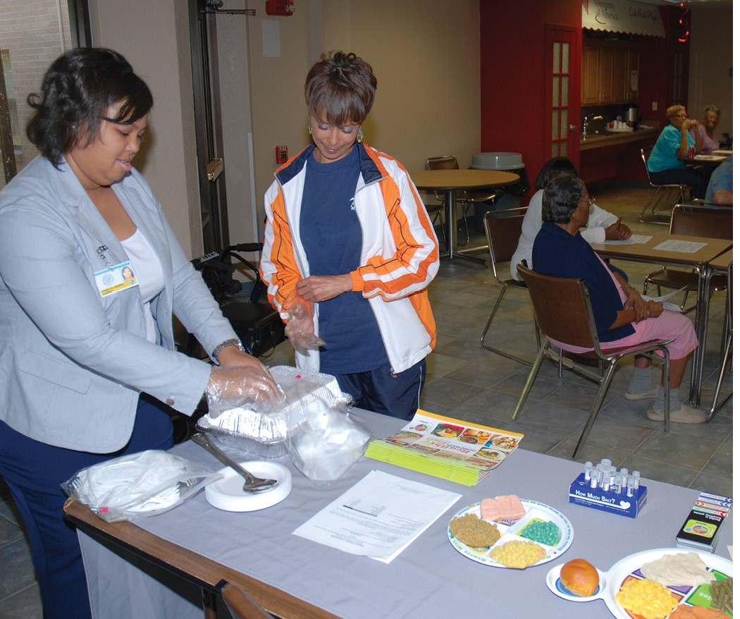 Photo of Marquetta Anderson, left, discusses healthful portions at a SNAP-Ed workshop
