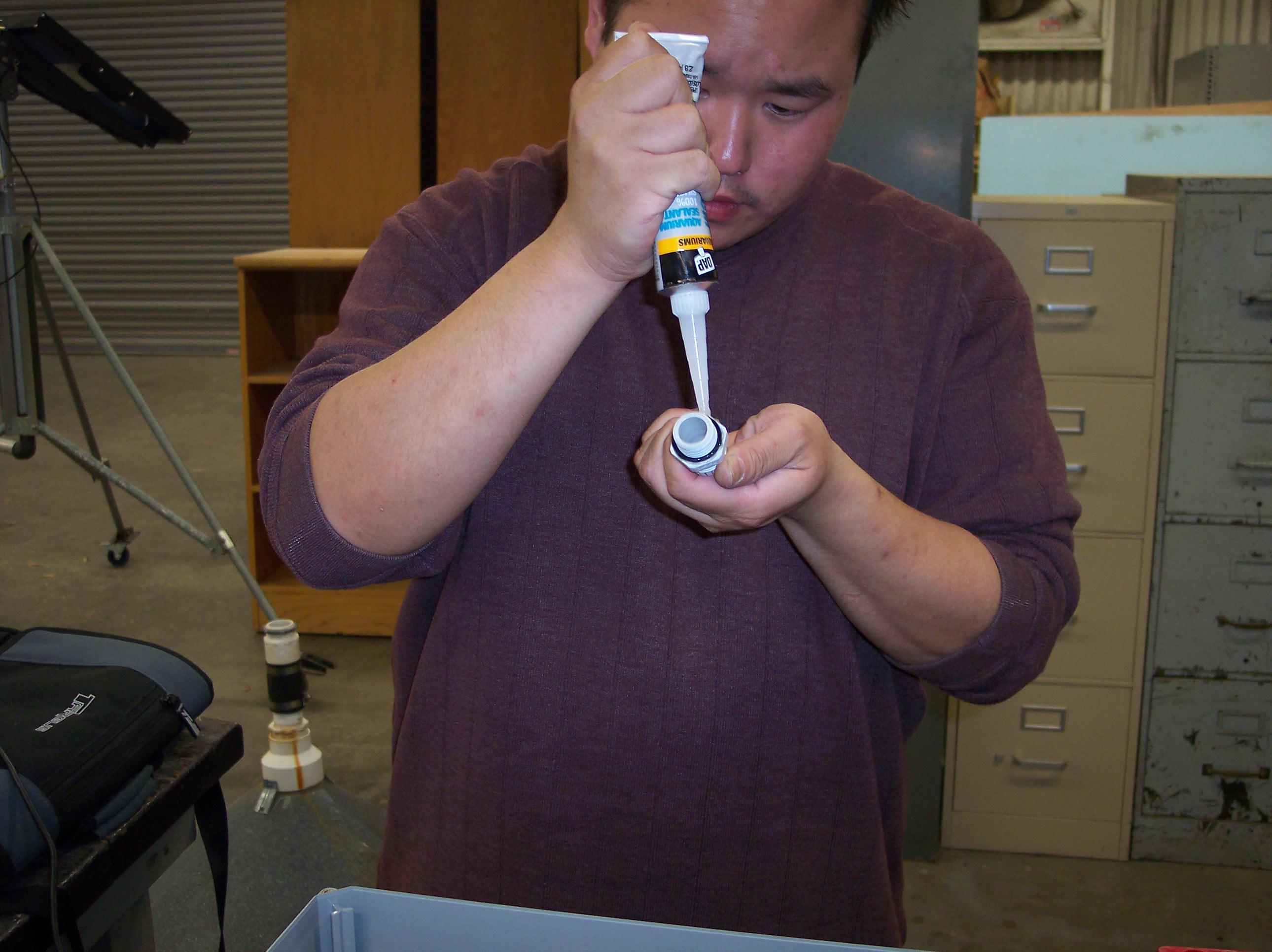 Jack Chiu adds sealant to one of the collars for the submersible data-acquisition enclosure.