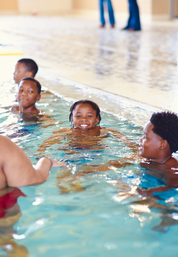 Four boys bob in the water during a swimming lesson. 