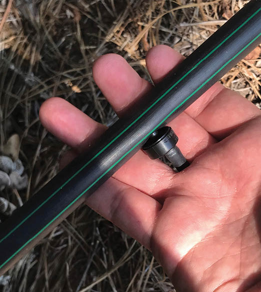 Photo of a hand holding an irrigation line.